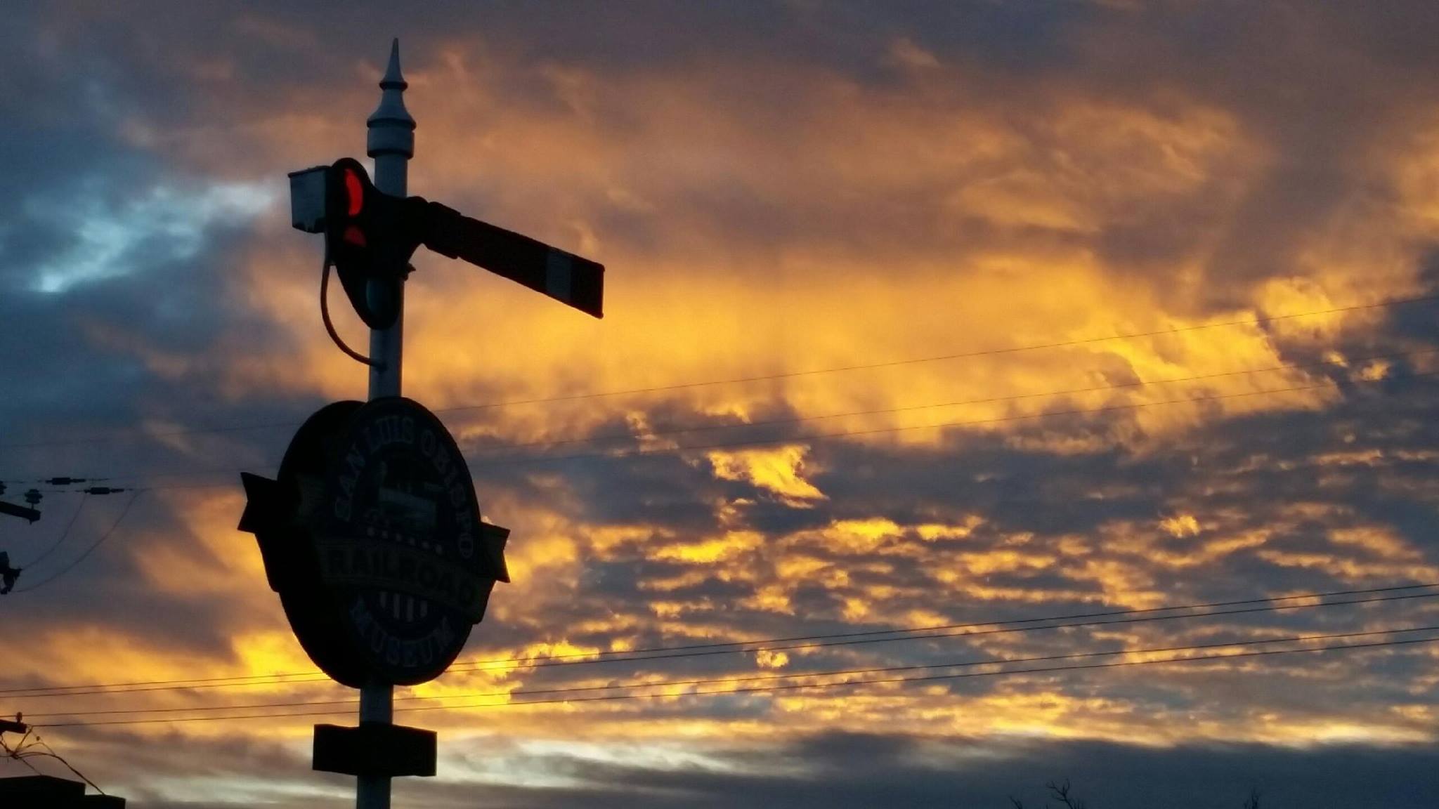 photo of museum sign with sunset clouds